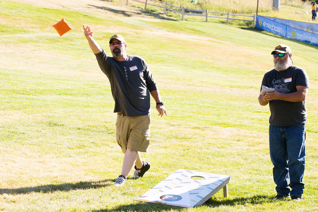 Utah team members enjoy a game of cornhole.